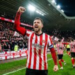 Sunderland footballer celebrates with fist pump, stadium crowd behind
